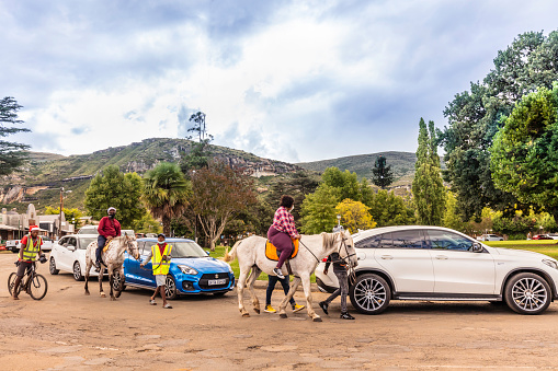 An overweight tourist travelling on a guided tour on horseback through the town of Clarens in the Free State of South Africa, Clarens is a small town featuring many restaurants and crafts, often nicknamed the 