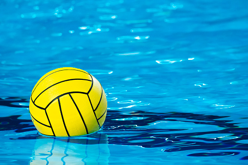 Water polo player in the pool\na ball