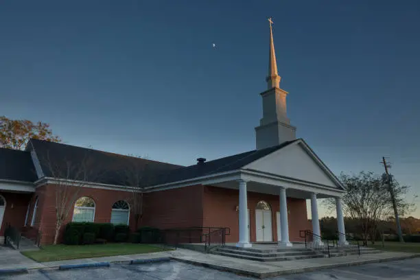 A small Baptist church with the twilight sun lighting up the steeple in rural Alabama.