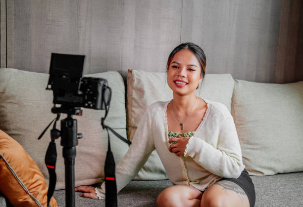 istock Asian blogger, podcaster or vlogger looking at camera and talking on video shooting with technology. Social media influencer people or content maker concept in relax casual style at home 1308679667