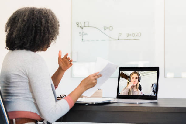 istock Teacher gestures while assisting young adult student via video conference 1308679933