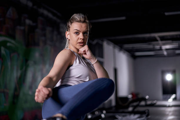 istock Young beautiful woman practicing side kick exercise in the gym 1308681159