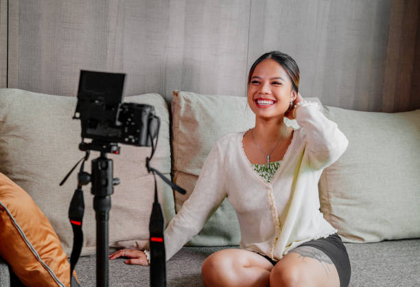 istock Asian blogger, podcaster or vlogger looking at camera and talking on video shooting with technology. Social media influencer people or content maker concept in relax casual style at home 1308681258