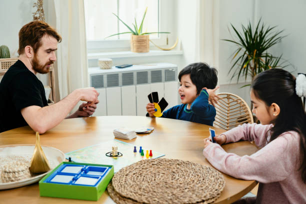 Father and kids playing with cards at the table