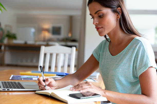 istock Caucasian woman sitting by desk working from home using laptop 1308685017