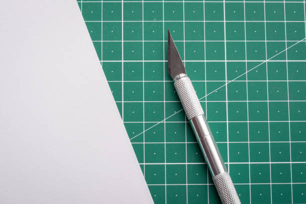 istock Scalpel near white paper on a table with cutting mat 1308685516