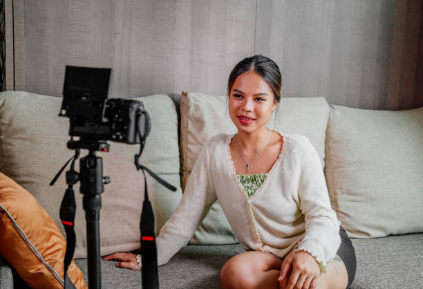 istock Asian blogger, podcaster or vlogger looking at camera and talking on video shooting with technology. Social media influencer people or content maker concept in relax casual style at home 1308686160