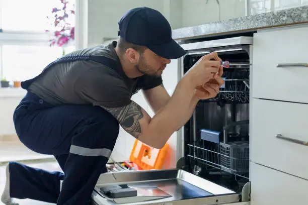 Photo of Technician examining dishwasher