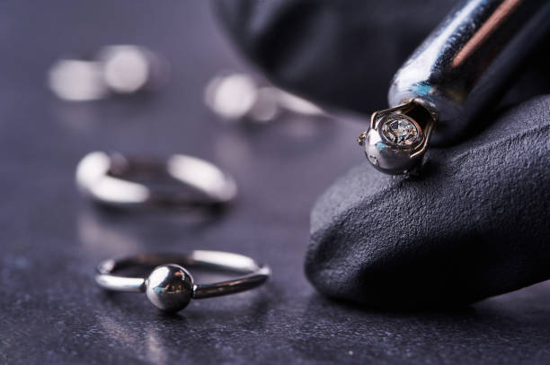 istock Piercing earrings close-up. On a black background 1308686344