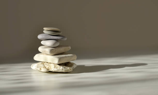 istock Balance pyramid stones on grey background, sunlight and shadows. Copy space 1308686945