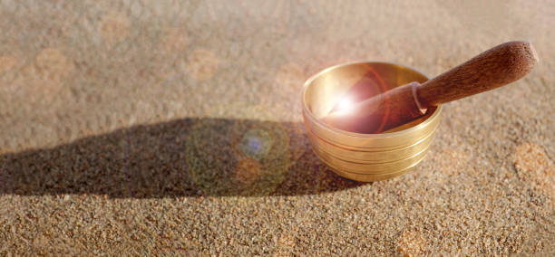 ヒマラヤチベット人は日光、ボケと砂の上にボウルを歌う。ハーモニーとリラクゼーションのコンセプト。スペースをコピーする - music wellbeing rin gong bowl ストックフォトと画像