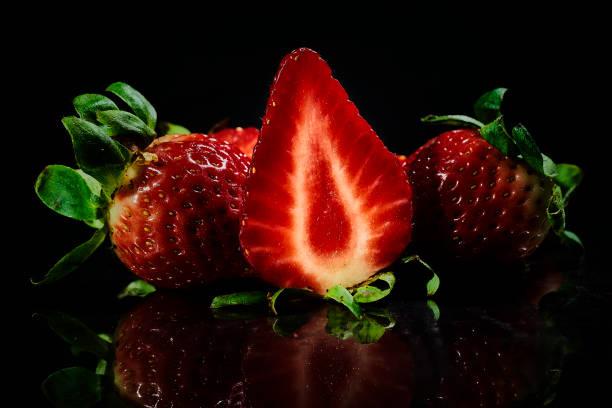 istock Strawberries with black background and reflection on metal. 1308689649