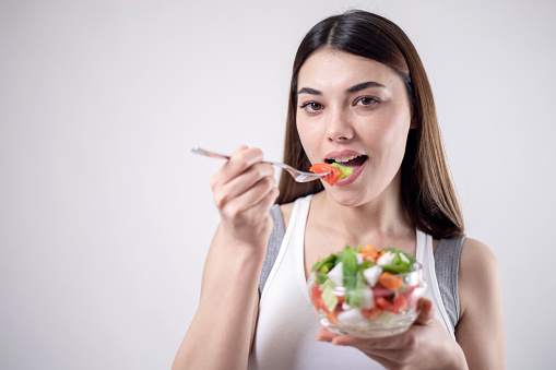 beautiful young woman eating salad