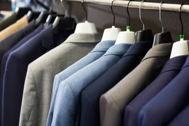 istock Men suits on hanger racks in shop 1308693017
