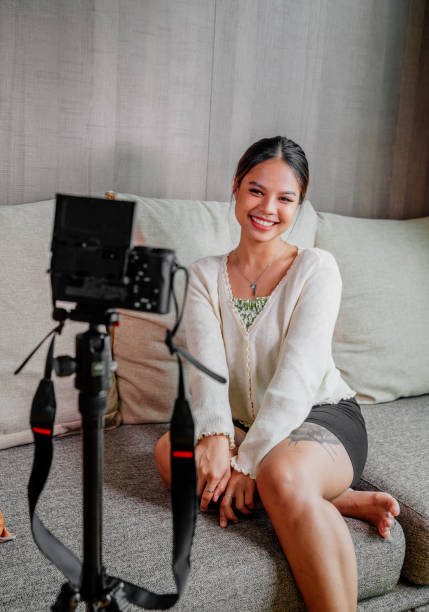 istock Asian blogger, podcaster or vlogger looking at camera and talking on video shooting with technology. Social media influencer people or content maker concept in relax casual style at home 1308694225