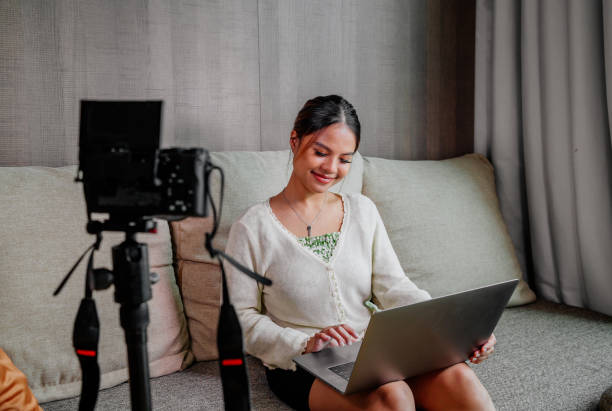 istock Asian blogger, podcaster or vlogger looking at camera and talking on video shooting with technology. Social media influencer people or content maker concept in relax casual style at home 1308695029