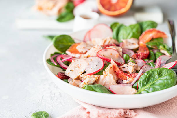 salada de salmão com laranja, espinafre e rabanete com ingrediente para fazer salada em tábua de corte de madeira. comida saudável. - orange fruit portion multi colored - fotografias e filmes do acervo