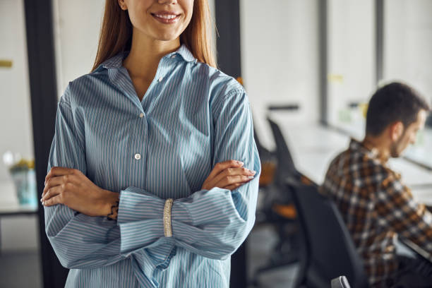 istock Joyous employee standing with her arms folded by her colleague 1308700203