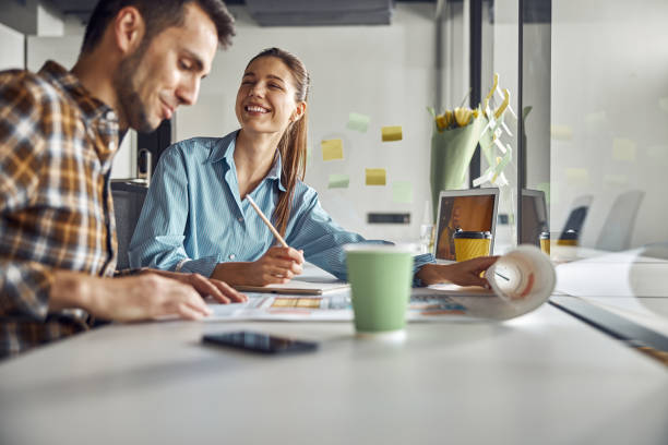 istock Draftsman and his merry coworker creating a new building plan 1308700261