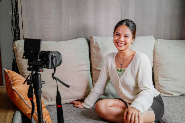 istock Asian blogger, podcaster or vlogger looking at camera and talking on video shooting with technology. Social media influencer people or content maker concept in relax casual style at home 1308701368