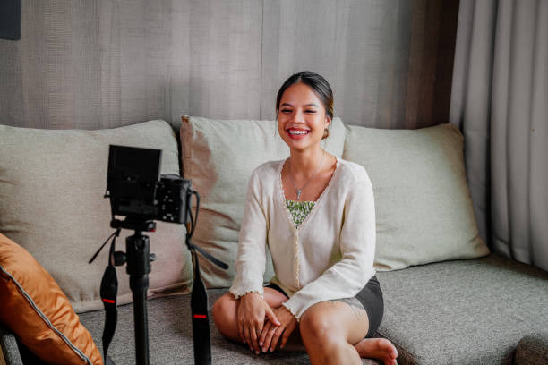 istock Asian blogger, podcaster or vlogger looking at camera and talking on video shooting with technology. Social media influencer people or content maker concept in relax casual style at home 1308701850