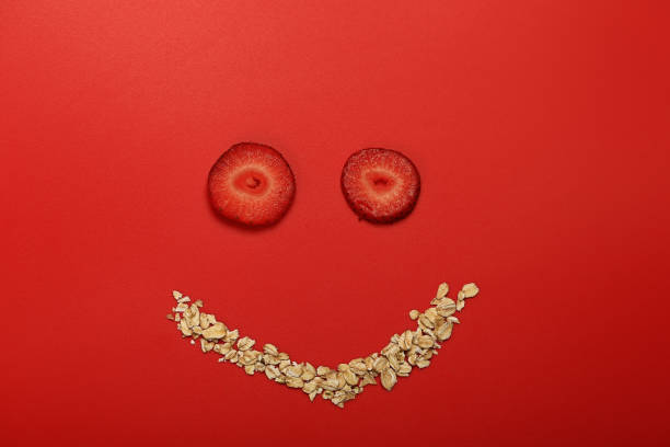 istock oatmeal with strawberries. Creative layout in the form of a face with a smile. Original design composition of healthy breakfast food 1308702425