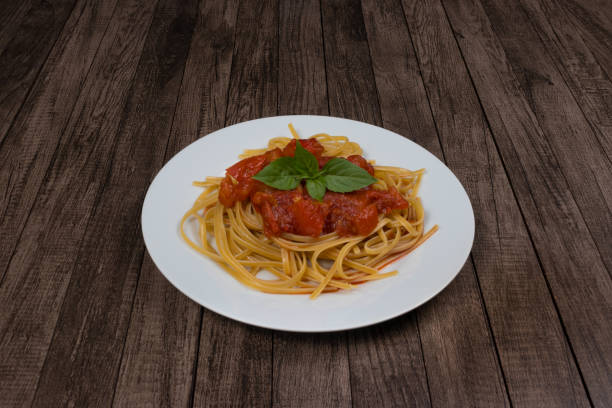 istock Pasta with rustic tomato sauce and basil leaves.Photograph with centralized elements and space for text. Gourmet photography. Typical food from Italy 1308703937