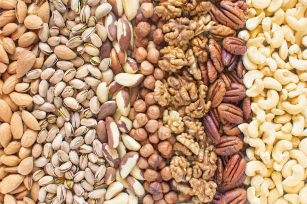 istock Assorted nuts banner background: hazelnuts walnuts, brazilian nuts, pecans, almonds, cashews. Flatlay organic mixed nuts banner. Useful health snack. Healthy food, useful microelements and vitamins. 1308704682