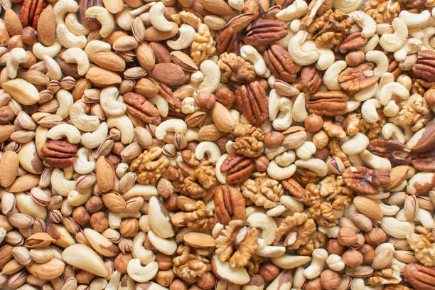 verschiedene nüsse: haselnüsse, walnüsse, brasilianische nüsse, pekannüsse, pistazien, mandeln, cashews flatlay bio gemischte nüsse hintergrund. gesunde ernährung, nützliche mikroelemente und vitamine. nützlicher gesundheitssnack. - low carb diet food healthy eating raw stock-fotos und bilder