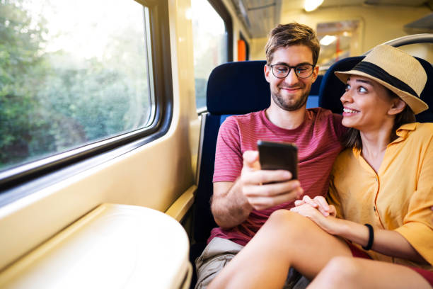 istock Smiling couple riding on the train and using phone together 1308705516