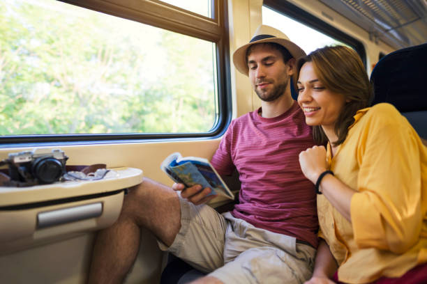 istock Young couple on the train reading the guidebook together 1308705530