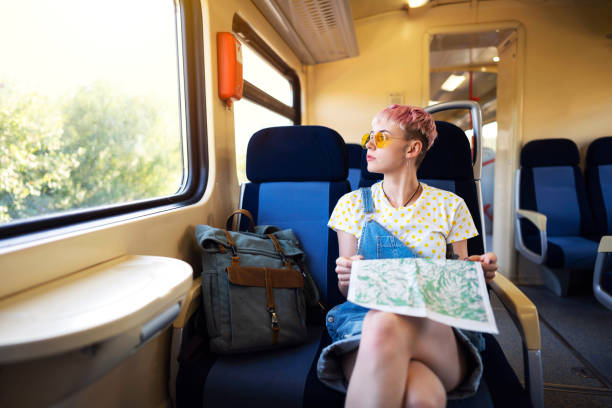 istock Young woman searching the city map while looking through the window on the train 1308705540