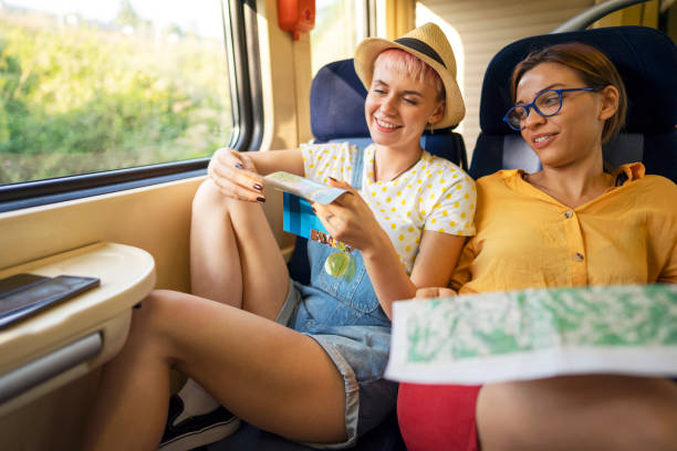 istock Two smiling female friends enjoying while riding on the train and searching the map 1308705541