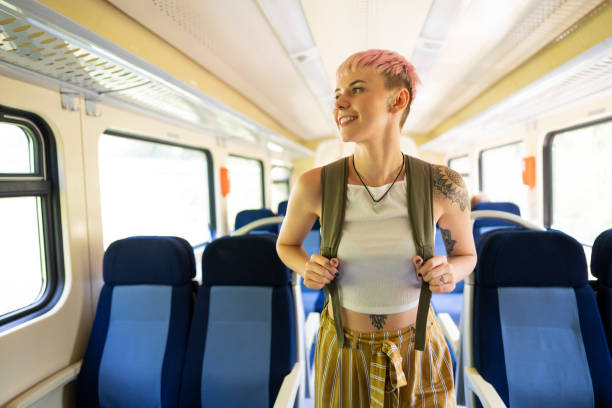 istock Smiling woman walking alone on the train 1308705584