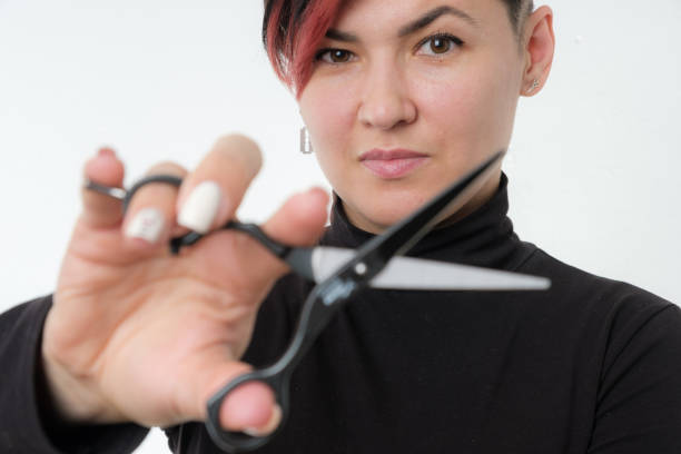 Half-length portrait of young adult barber woman on white background holding metal professional hairdressing scissors, modern barber girl concept Half length portrait of young adult barber woman on white background holding metal professional hairdressing scissors, modern barber girl concept scissors photos stock pictures, royalty-free photos & images