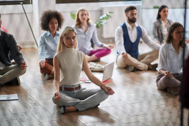 istock Woman meditating at work.coworkers meditating together at work. 1308711685
