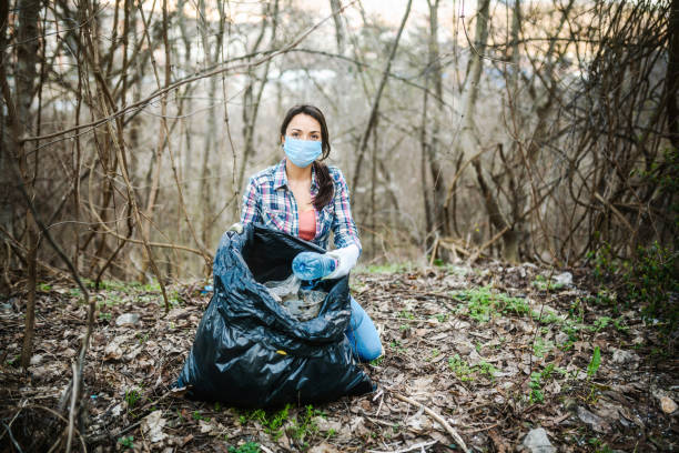 istock Young woman picking plastic waste in the nature. 1308720002