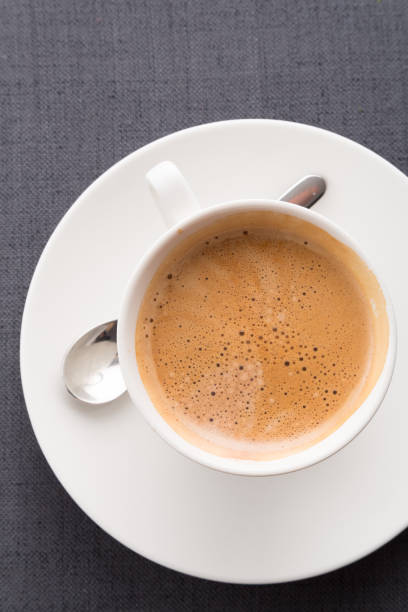 istock Hot coffee in white mug on gray fabric background 1308721732