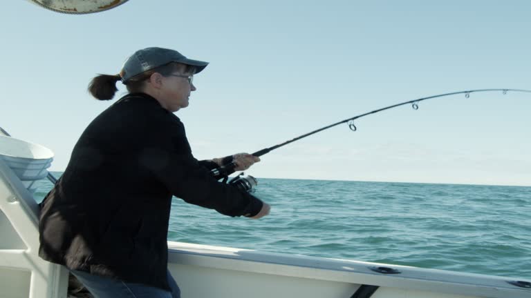 Middle Aged Woman Reeling In, Catching A Fish On a Fishing Charter Boat, Puerto Penasco, Sea of Cortez