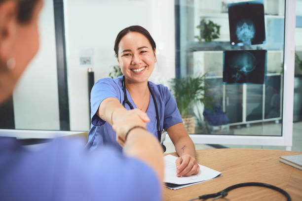 Let's save more lives together Shot of doctors shaking hands during a meeting in a hospital changing form stock pictures, royalty-free photos & images