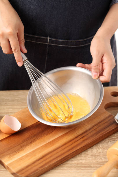 istock Young woman cooking omelet on wooden table 1308751797