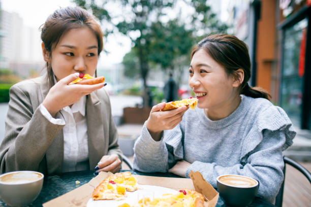 istock Young girls eating pizza 1308752926