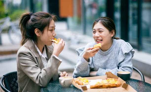 Friends eating pizza Friends eating pizza chinese ethnicity china restaurant eating stock pictures, royalty-free photos & images