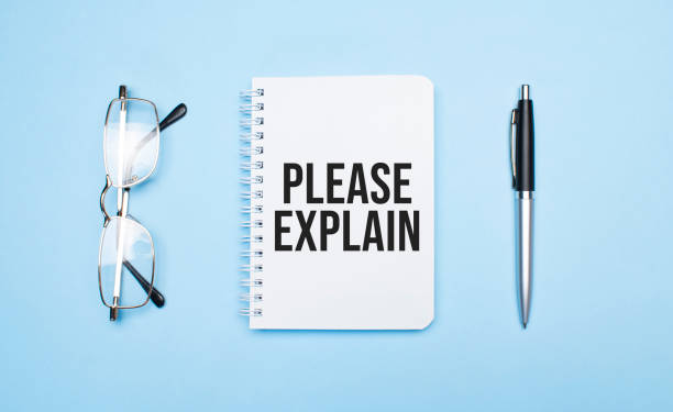 istock PLEASE EXPLAIN words in white notepad, pen and glasses on blue background. Concept 1308755147