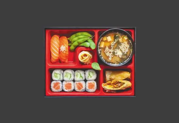 Japanese Bento Box with Sushi Rolls, Kimchi Salad and Spring rolls. Healthy lunch