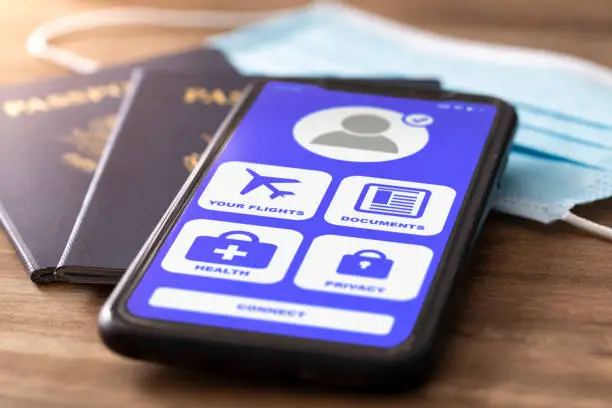 A smart phone with vaccine passport app on phone that is required for travel along with passport and face covering(mask).

***Note to Inspector - The Covid-19 vaccine passport app is of my own design.