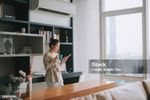 Asian Chinese Beautiful Woman Enjoying Her Afternoon Tea At Living Room Looking Outside Window Relax Leaning On Table Stock Photo - Download Image Now