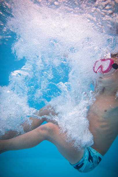 istock Cute little boy in a swimming pool 1308767200