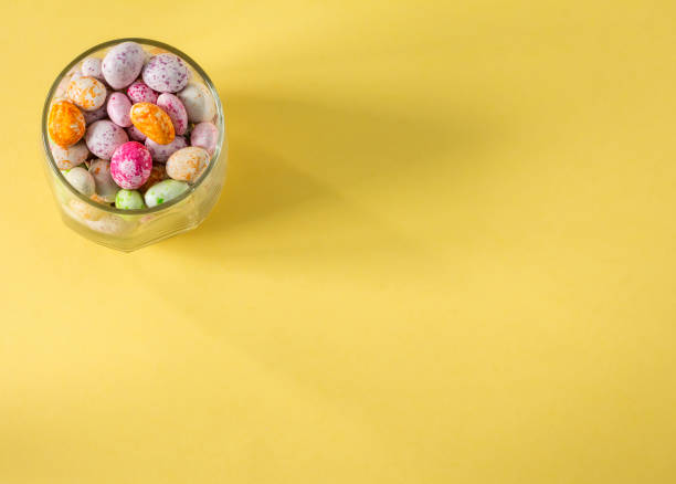 istock glass cup with colored candies on a yellow background top view flat masonry with a copy of the space 1308768057