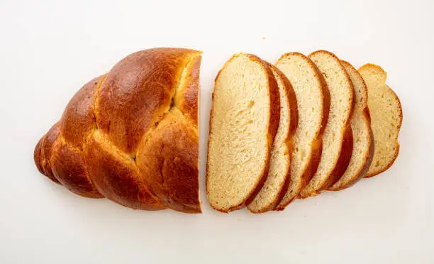 Easter sweet bread, tsoureki cozonac loaf slices isolated on white background, top view. Braided brioche, challah. Festive traditional religion dessert.